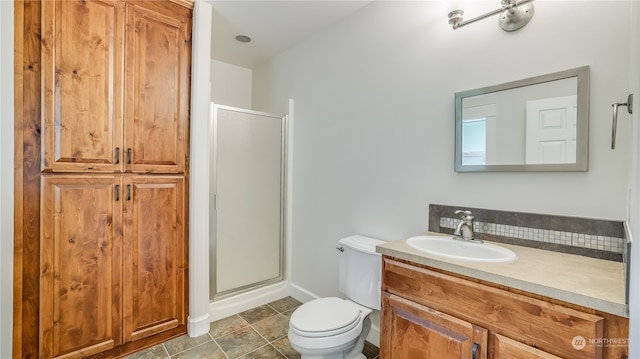 bathroom with vanity, toilet, and a shower with door