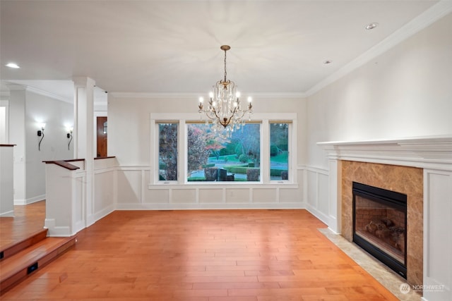 unfurnished living room with crown molding, a fireplace, and light wood-type flooring