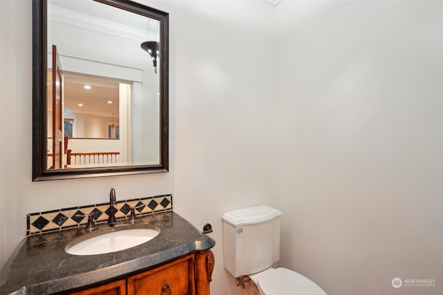 bathroom with vanity, toilet, and ornamental molding