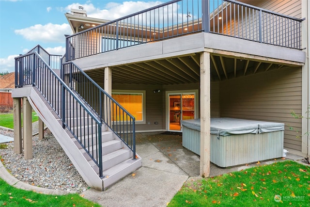 view of patio / terrace with a hot tub and a deck