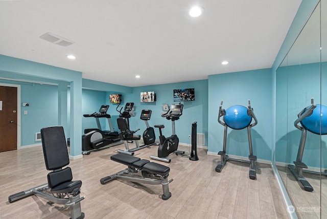 workout area with light hardwood / wood-style floors