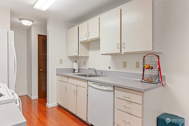 kitchen featuring white appliances, light hardwood / wood-style floors, and sink