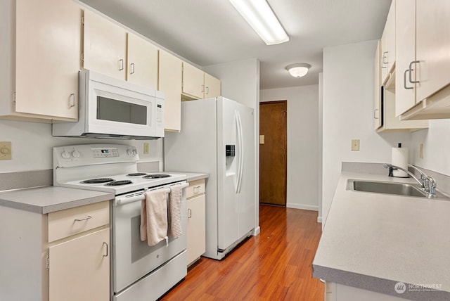 kitchen with sink, light hardwood / wood-style flooring, and white appliances