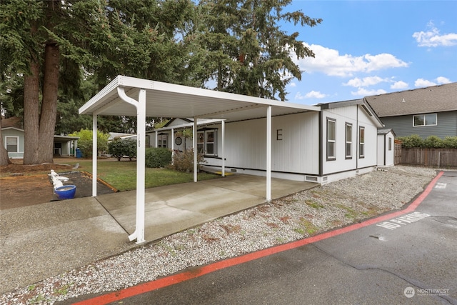 manufactured / mobile home featuring a carport, a storage unit, and a front lawn