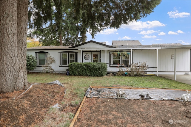 view of front of home with a front lawn and a carport