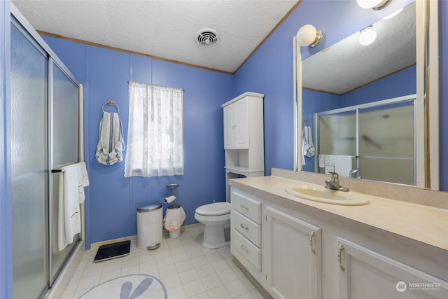 bathroom with tile patterned floors, toilet, vanity, a textured ceiling, and an enclosed shower