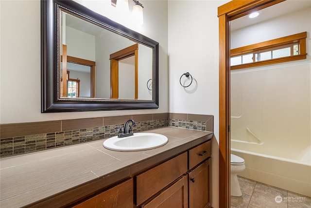 full bathroom with vanity, backsplash, shower / washtub combination, tile patterned flooring, and toilet