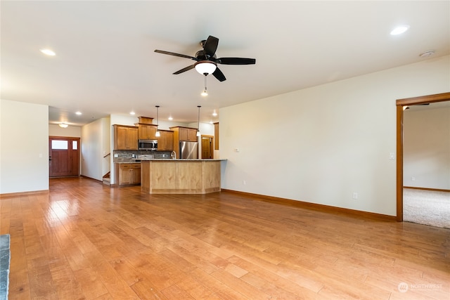 unfurnished living room with ceiling fan and light wood-type flooring