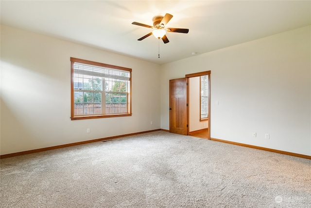 empty room featuring ceiling fan and light carpet