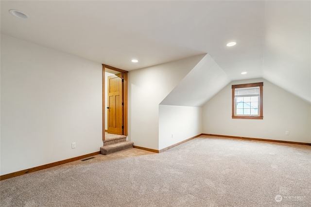 additional living space with light carpet and lofted ceiling