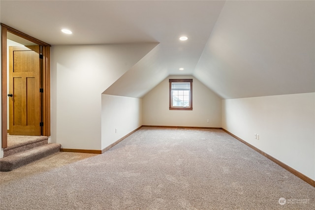 additional living space featuring carpet flooring and vaulted ceiling