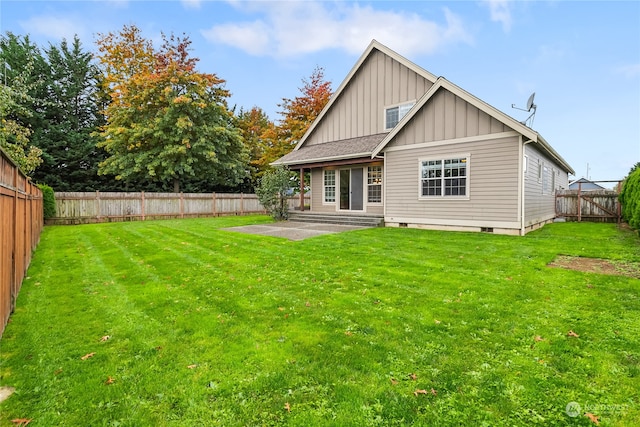 rear view of property with a patio area and a yard