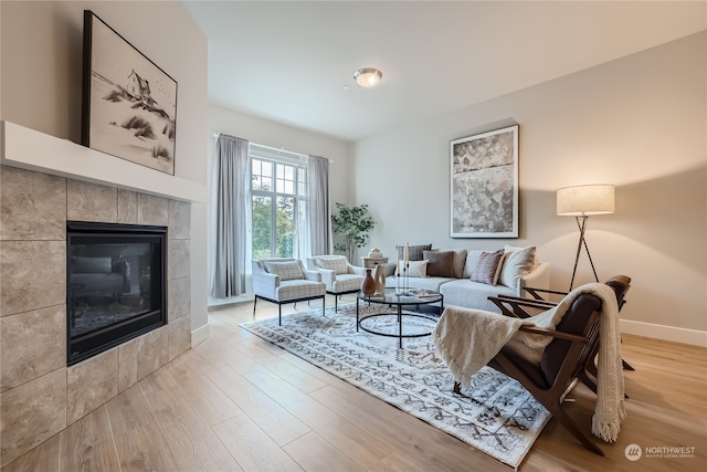 living room featuring light wood-type flooring and a tile fireplace