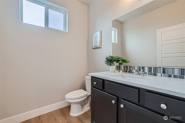 bathroom with toilet, tasteful backsplash, vanity, and wood-type flooring