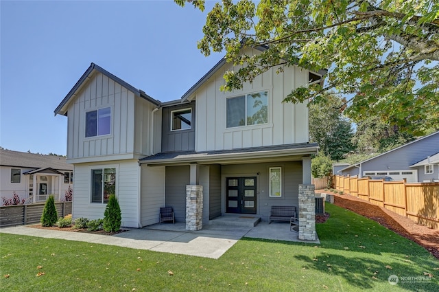 back of property with a patio, central AC, and a lawn