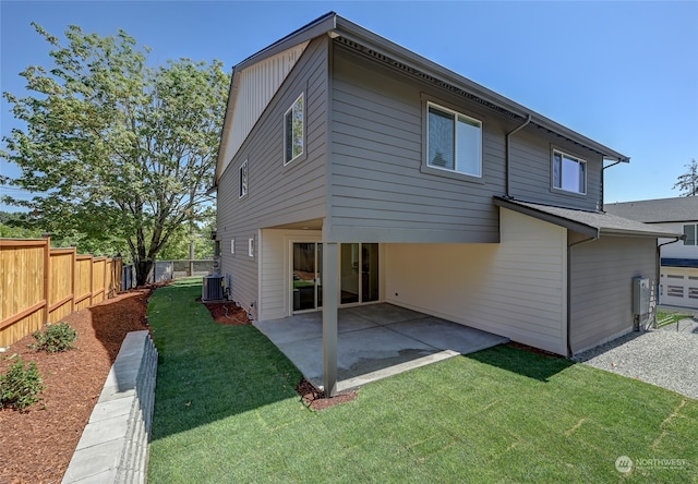 rear view of property with a patio, central AC, and a lawn