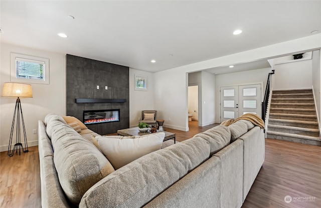 living room with hardwood / wood-style floors and a tiled fireplace