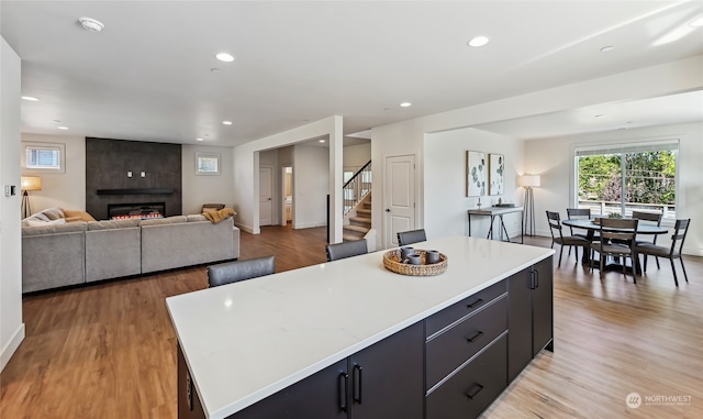 kitchen featuring a spacious island, light hardwood / wood-style floors, and a fireplace