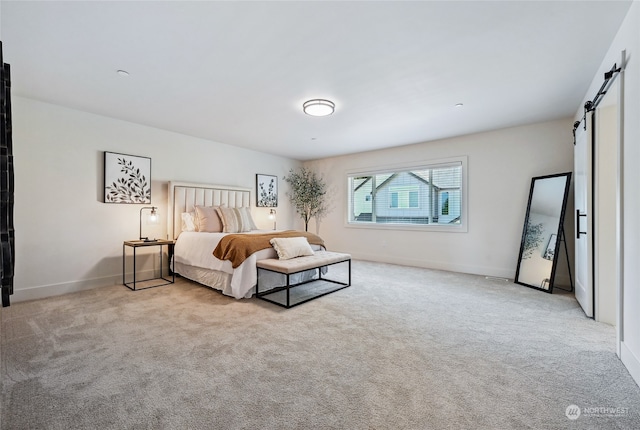 bedroom featuring a barn door and light colored carpet