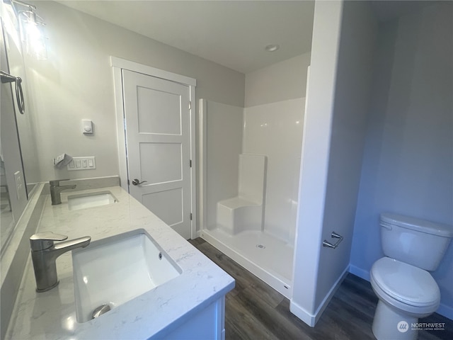 bathroom featuring vanity, a shower, hardwood / wood-style flooring, and toilet