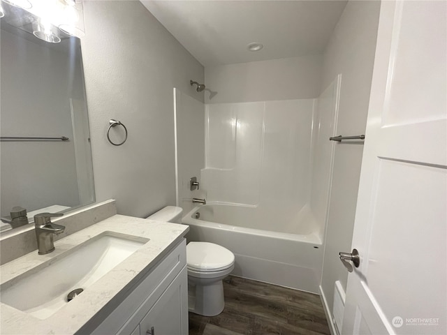 full bathroom featuring  shower combination, vanity, wood-type flooring, and toilet