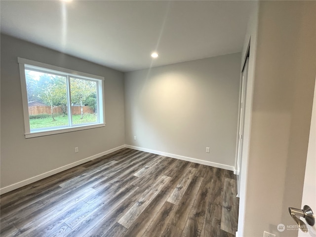 unfurnished room with dark wood-type flooring