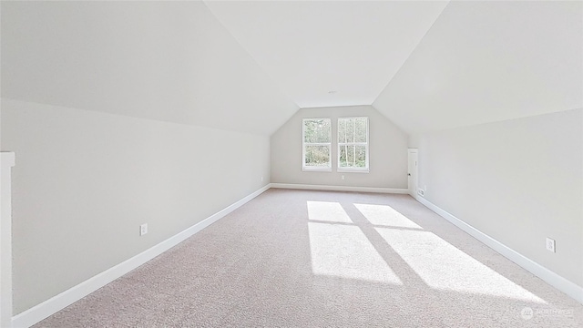 additional living space with vaulted ceiling and light carpet