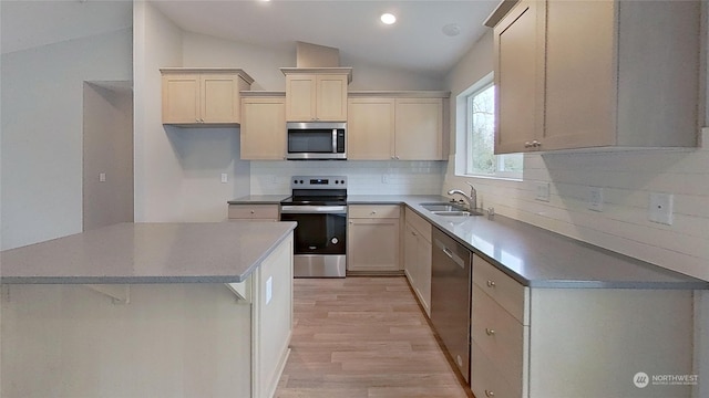 kitchen featuring sink, light hardwood / wood-style flooring, backsplash, stainless steel appliances, and vaulted ceiling