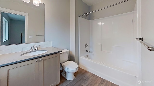 full bathroom featuring wood-type flooring, toilet, shower / bathing tub combination, and vanity