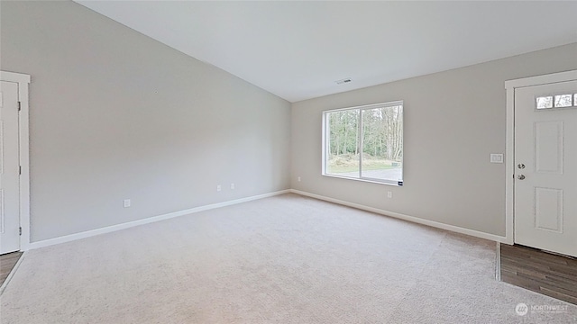 entryway featuring lofted ceiling and light carpet