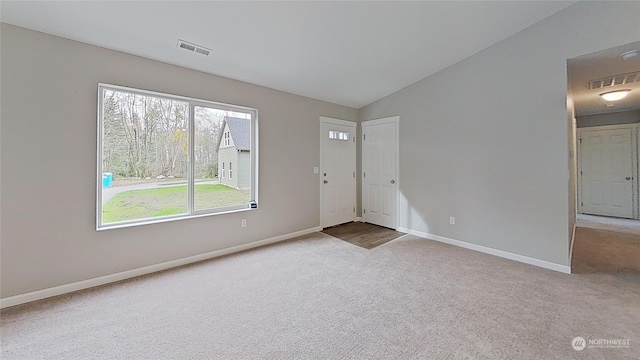 carpeted spare room with lofted ceiling