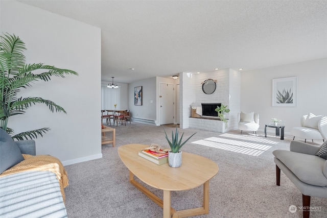 living room with a baseboard heating unit, a brick fireplace, a textured ceiling, and light colored carpet