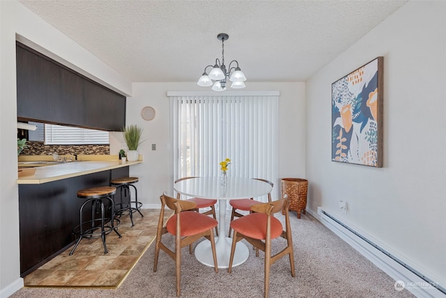 carpeted dining room with a baseboard radiator, a textured ceiling, and an inviting chandelier