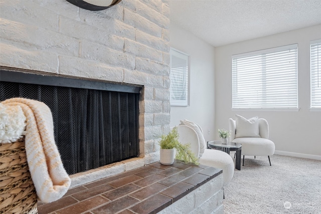 sitting room featuring a textured ceiling, carpet flooring, and a fireplace