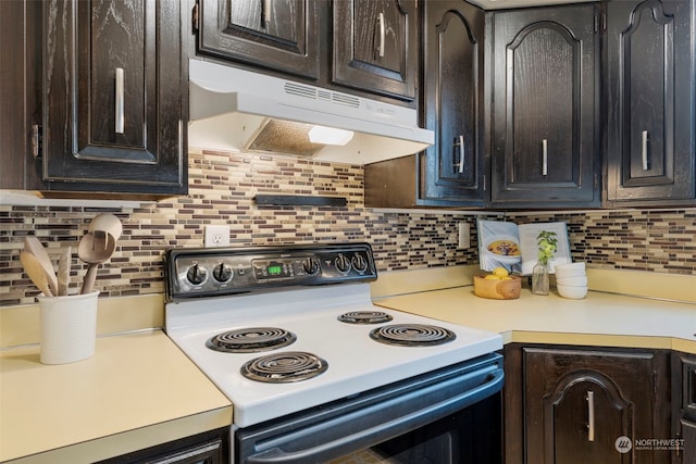 kitchen featuring dark brown cabinetry, white electric range oven, and backsplash