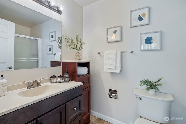 bathroom featuring vanity, toilet, and a shower with shower door