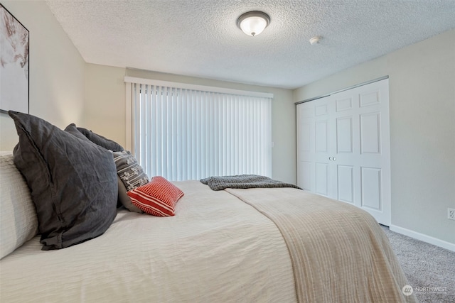 carpeted bedroom featuring a closet and a textured ceiling