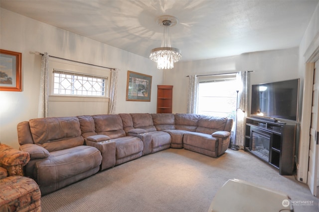 living room featuring a chandelier, light carpet, and a healthy amount of sunlight