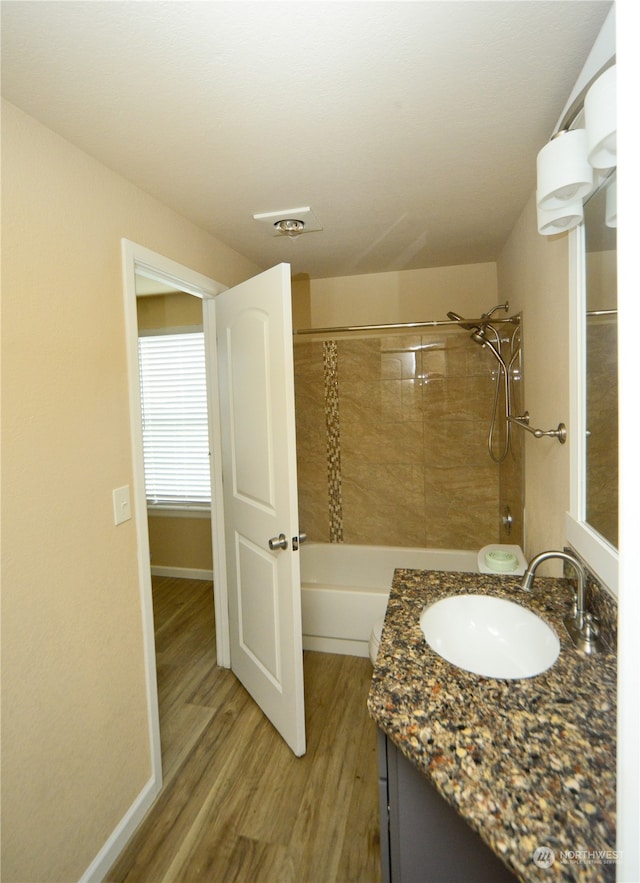 bathroom featuring vanity, tiled shower / bath combo, and hardwood / wood-style floors