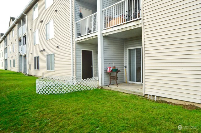 exterior space featuring a balcony and a yard