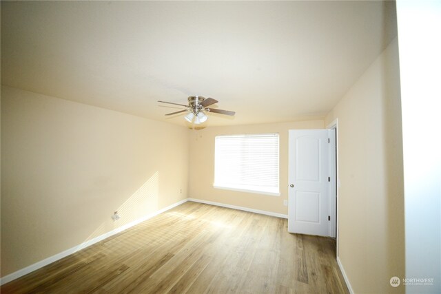 spare room with light wood-type flooring and ceiling fan