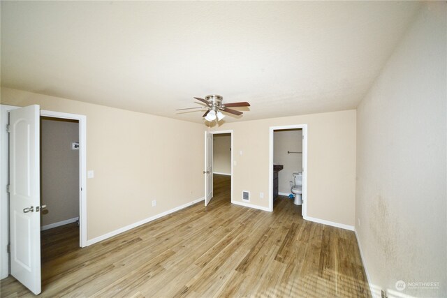 unfurnished bedroom with connected bathroom, ceiling fan, light hardwood / wood-style flooring, and a walk in closet