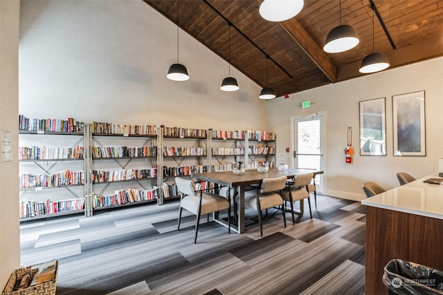 dining space featuring baseboards, high vaulted ceiling, beam ceiling, wood ceiling, and carpet flooring