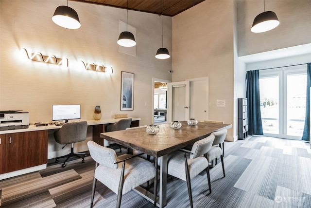 dining room with baseboards and a towering ceiling