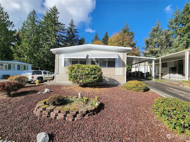 view of front facade featuring a carport, concrete driveway, and board and batten siding