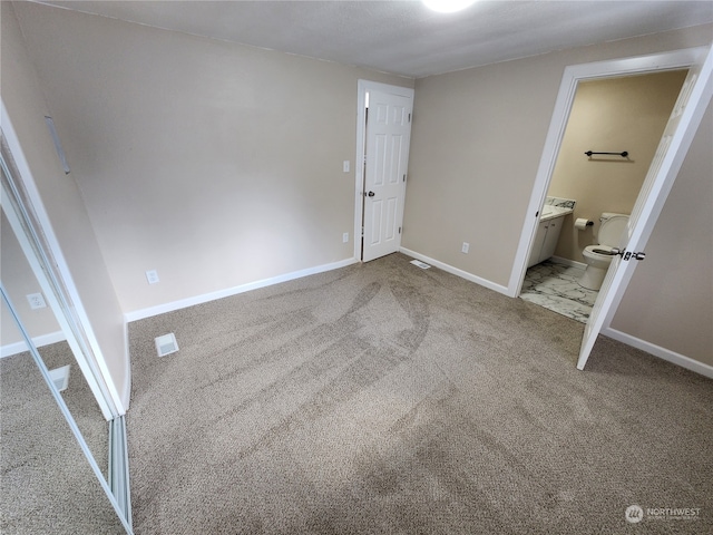 unfurnished bedroom with ensuite bath, carpet, and baseboards