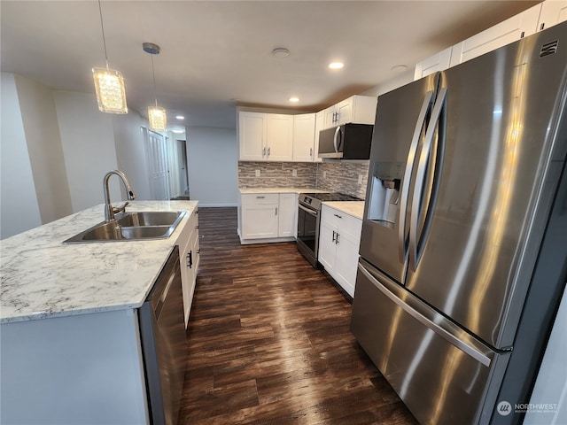 kitchen with a sink, backsplash, dark wood finished floors, white cabinetry, and stainless steel appliances