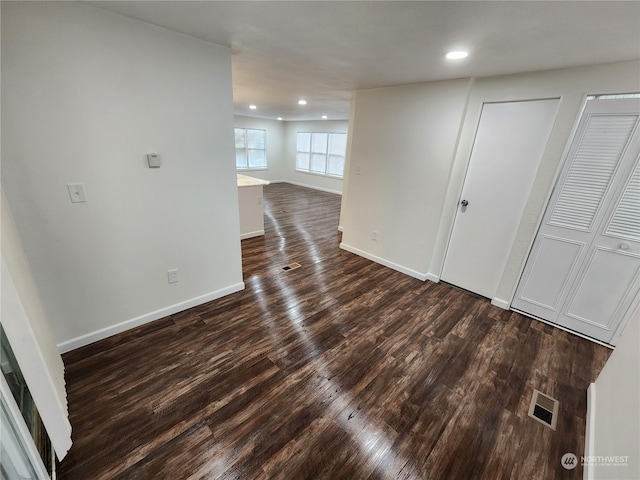 unfurnished room featuring recessed lighting, visible vents, baseboards, and dark wood-style flooring