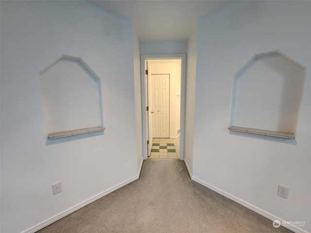 hallway featuring light colored carpet