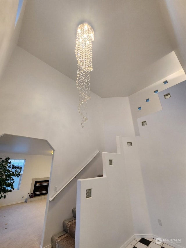 151 Rilla Ln, Sequim, WA 98382 - stairway with a high ceiling, a chandelier, baseboards, and a tiled fireplace